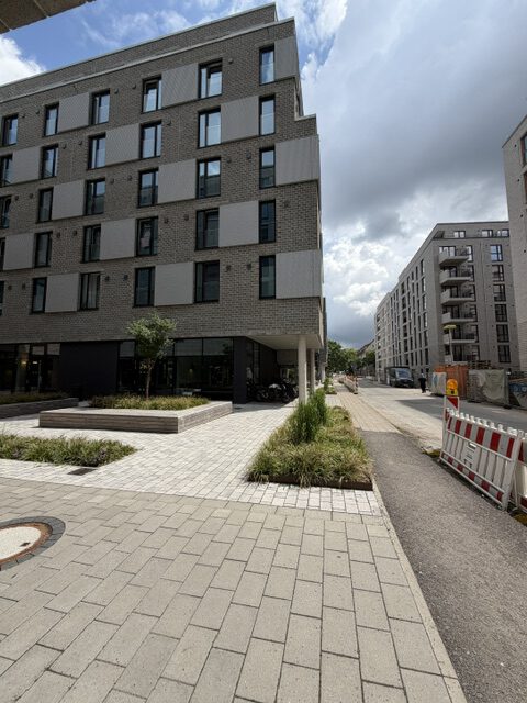 Fine Arts Campus Hamburg: Gebäudeecke mit Pflanzbeeten an der Straße